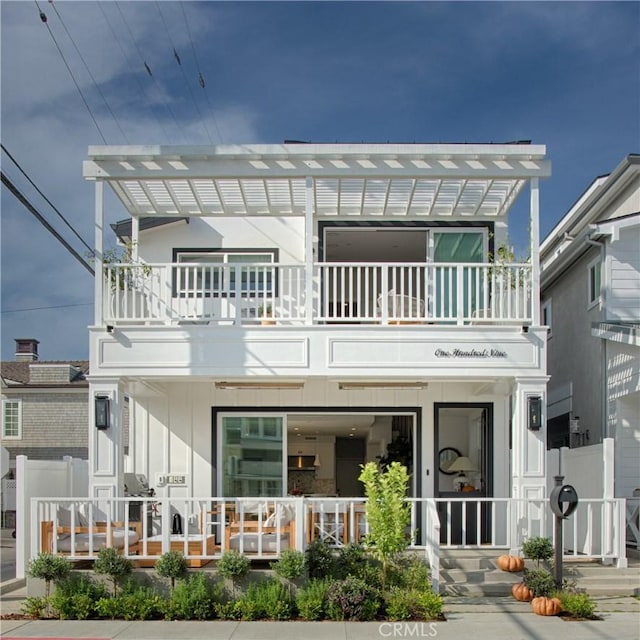 back of house with a balcony, fence, and a pergola