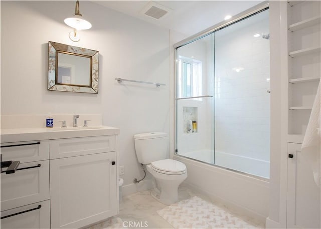 full bathroom featuring toilet, vanity, combined bath / shower with glass door, and baseboards