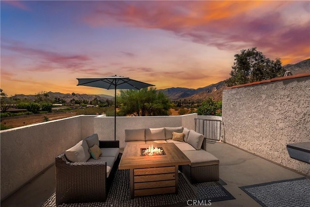 280 S Avenida Caballeros Unit 266, Palm Springs, CA 92262 - patio terrace at dusk featuring an outdoor living space with a fire pit and a mountain view