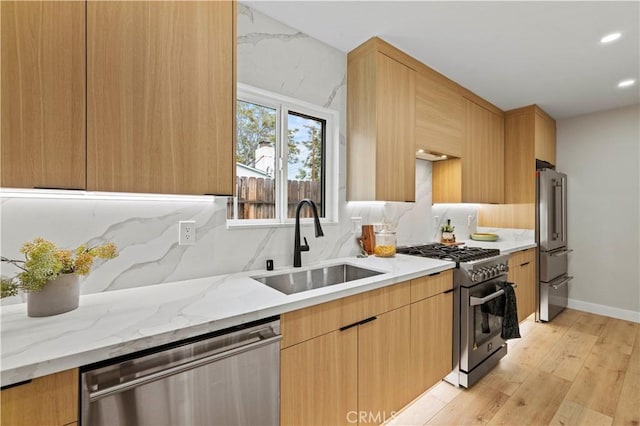 6838 Belmar Ave, Reseda, CA 91335 - kitchen featuring high end appliances, a sink, light wood-style flooring, light stone countertops, and tasteful backsplash