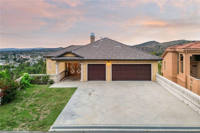 12336 Circula Panorama, North Tustin, CA 92705 - view of front of house with an attached garage, concrete driveway, a yard, a chimney, and a mountain view