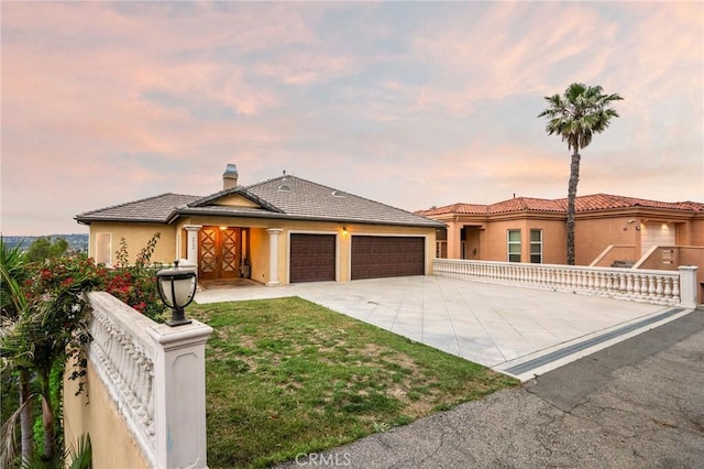 12336 Circula Panorama, North Tustin, CA 92705 - view of front facade featuring an attached garage, driveway, stucco siding, and a chimney