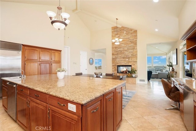 12336 Circula Panorama, North Tustin, CA 92705 - kitchen with a kitchen island, high vaulted ceiling, appliances with stainless steel finishes, a stone fireplace, and light stone counters