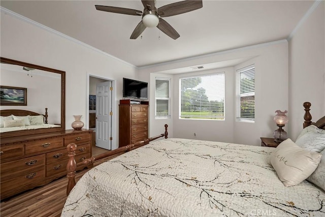 bedroom featuring ornamental molding, wood finished floors, and a ceiling fan