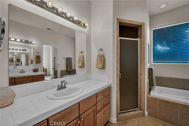 bathroom with a shower stall, tile patterned floors, a garden tub, and vanity