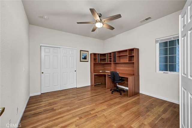 office area with wood finished floors, a ceiling fan, and baseboards