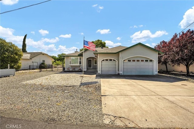 view of front facade featuring an attached garage, driveway, and fence