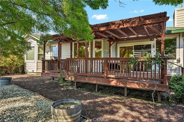 back of property featuring a pergola and a deck