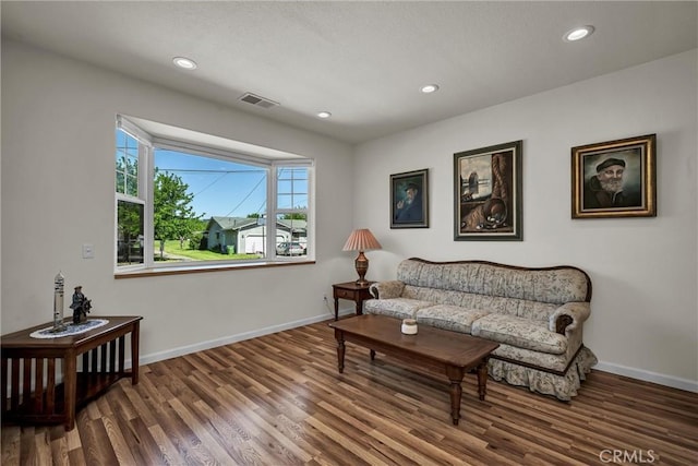 living area featuring wood finished floors, baseboards, and recessed lighting