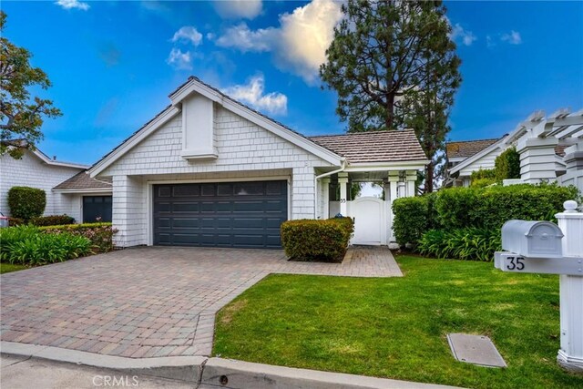 single story home with a garage, a front yard, and decorative driveway