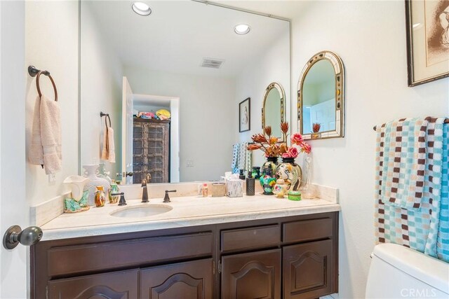 bathroom featuring recessed lighting, vanity, and toilet