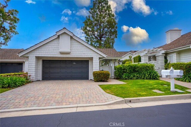 single story home with a garage, a front yard, and driveway