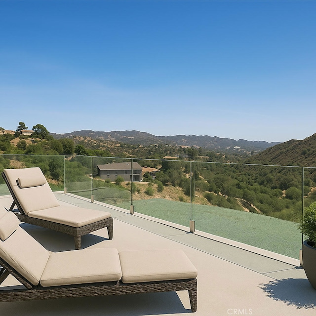 view of patio with a mountain view and a balcony