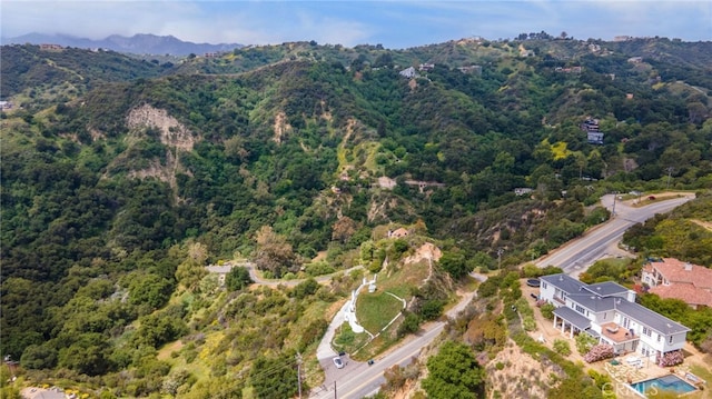 aerial view of a heavily wooded area and a mountain backdrop