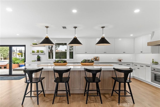 20011 Colgate Cir, Huntington Beach, CA 92646 - kitchen with oven, premium range hood, light countertops, open shelves, and white cabinets