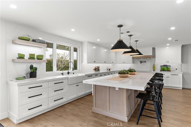 20011 Colgate Cir, Huntington Beach, CA 92646 - kitchen with a sink, light countertops, a center island, white cabinets, and light wood finished floors