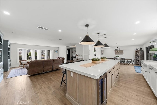 20011 Colgate Cir, Huntington Beach, CA 92646 - kitchen with beverage cooler, open floor plan, a spacious island, light wood-type flooring, and a kitchen bar