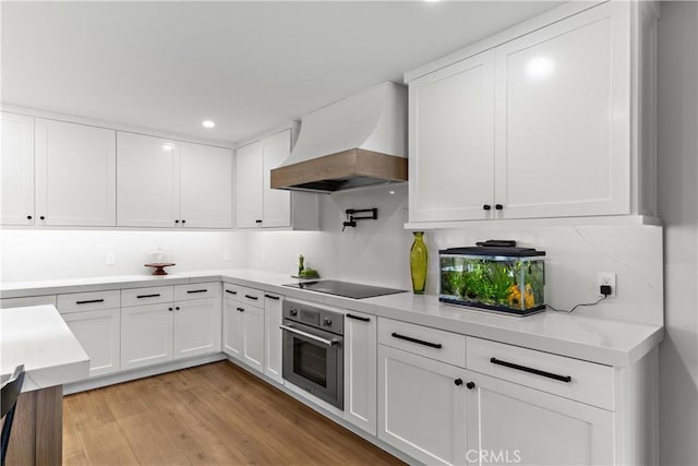 20011 Colgate Cir, Huntington Beach, CA 92646 - kitchen with stainless steel oven, premium range hood, black electric cooktop, white cabinetry, and recessed lighting