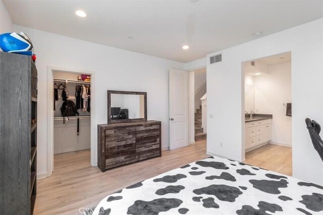 177 Frame, Irvine, CA 92618 - bedroom featuring light wood finished floors, a walk in closet, a closet, connected bathroom, and recessed lighting