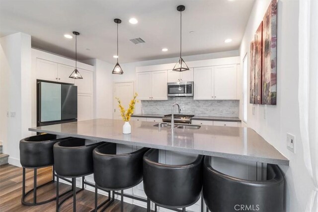 177 Frame, Irvine, CA 92618 - kitchen featuring appliances with stainless steel finishes, a sink, decorative backsplash, a kitchen breakfast bar, and recessed lighting