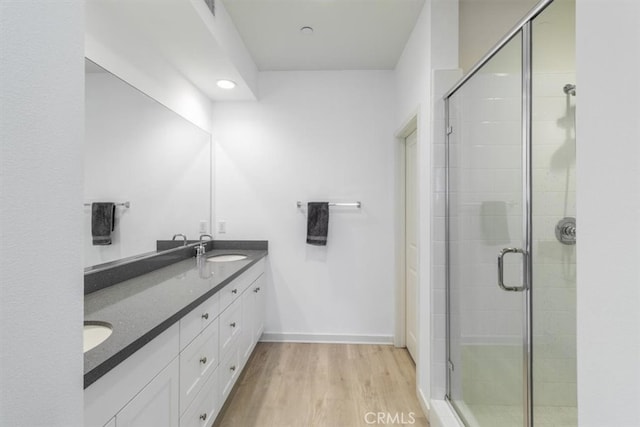 177 Frame, Irvine, CA 92618 - bathroom with double vanity, wood finished floors, a shower stall, and baseboards