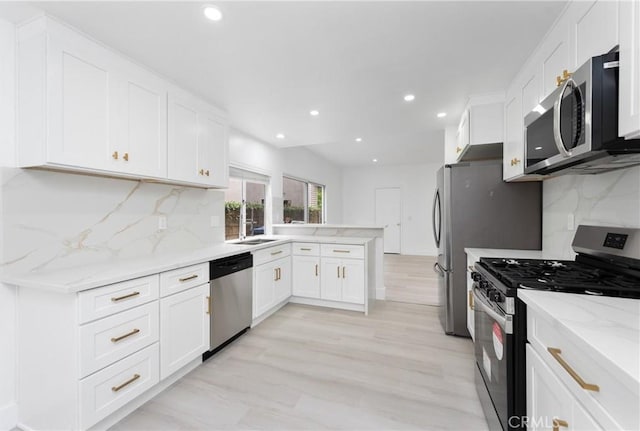 12029 Bubbling Brook St, Moorpark, CA 93021 - kitchen with appliances with stainless steel finishes, a peninsula, light stone counters, white cabinets, and recessed lighting