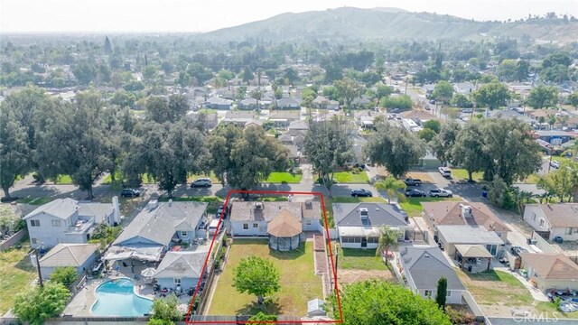 3465 Sepulveda Ave, San Bernardino, CA 92404 - aerial view of residential area with property boundaries highlighted, a mountainous background, and a pool
