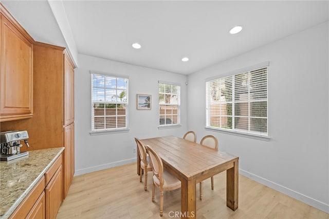 dining room featuring baseboards, light wood finished floors, and recessed lighting