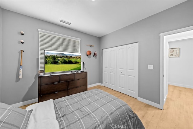 bedroom featuring light wood-type flooring, a closet, and baseboards