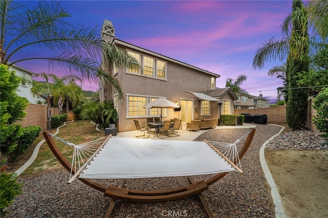 back of house featuring stucco siding, a fenced backyard, and a patio area