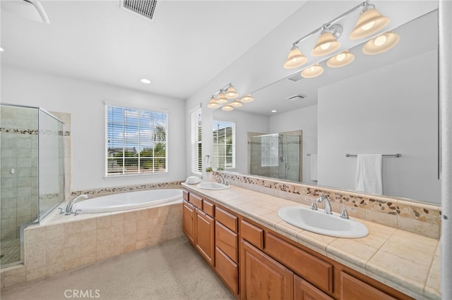 full bathroom with a stall shower, a garden tub, double vanity, and recessed lighting