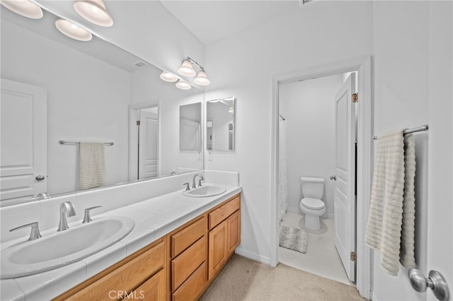 bathroom with double vanity and toilet