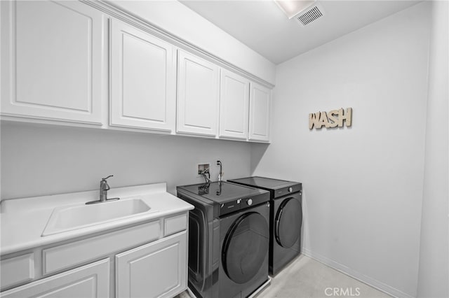 washroom with cabinet space, independent washer and dryer, and baseboards