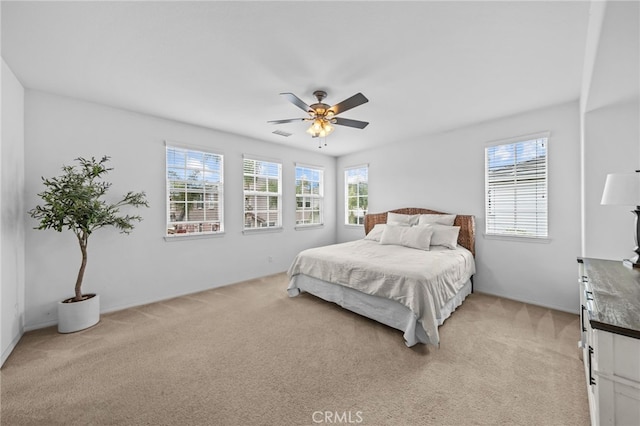 bedroom featuring light colored carpet, baseboards, and ceiling fan