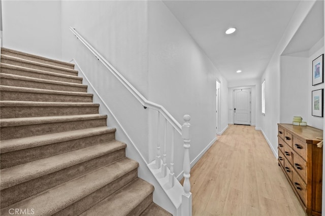 stairway with recessed lighting, wood finished floors, and baseboards