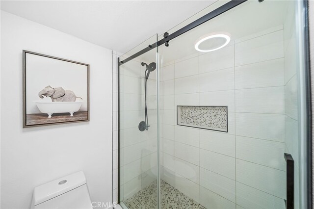 bathroom with toilet and a stall shower