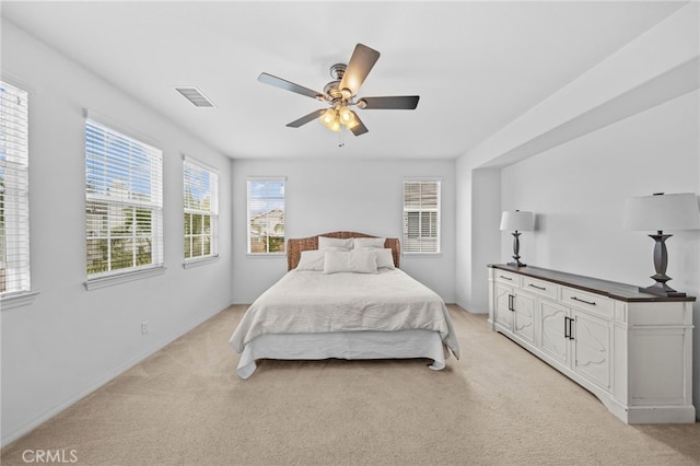 bedroom featuring light carpet, a ceiling fan, and baseboards