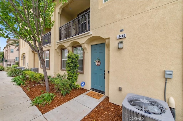 12440 Constellation St, Eastvale, CA 91752 - property entrance with cooling unit, stucco siding, and fence