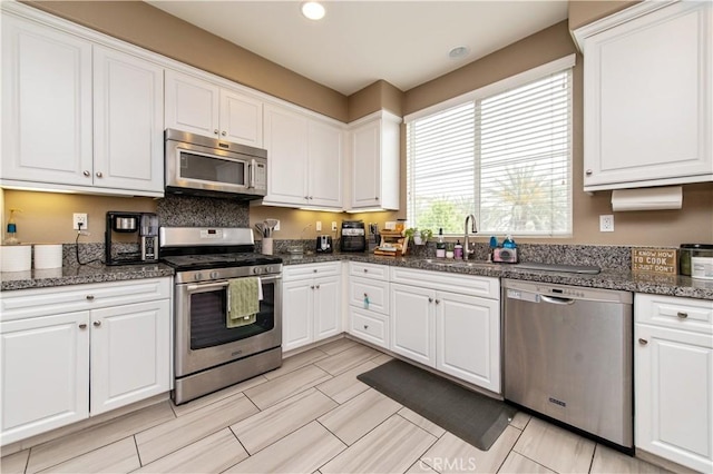 12440 Constellation St, Eastvale, CA 91752 - kitchen with stainless steel appliances, a sink, white cabinets, recessed lighting, and dark stone counters