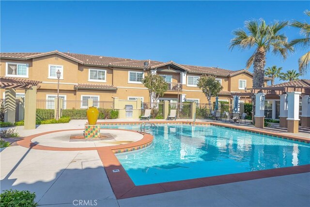 community pool with a pergola, fence, a residential view, and a patio
