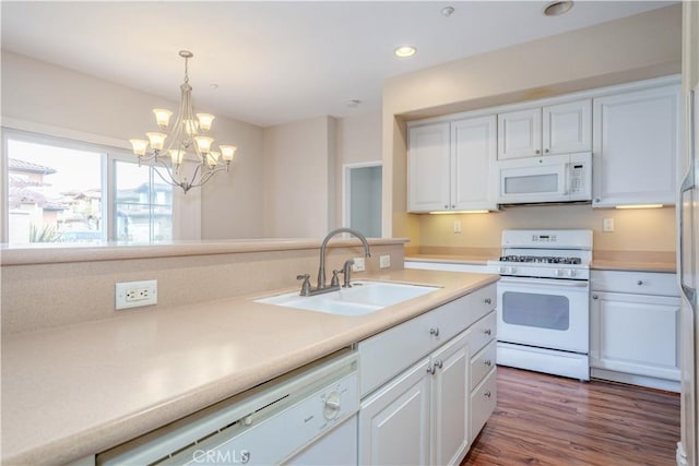 kitchen featuring white appliances, a sink, white cabinetry, a chandelier, and recessed lighting
