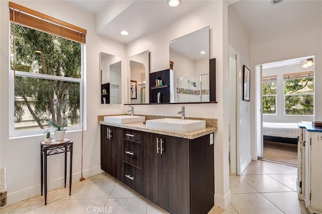 ensuite bathroom with tile patterned floors, baseboards, a stall shower, double vanity, and recessed lighting