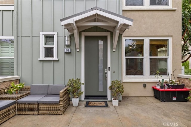 46 Beacon Way, Aliso Viejo, CA 92656 - doorway to property with board and batten siding, a patio area, and outdoor lounge area