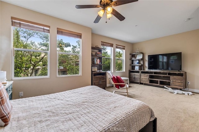 carpeted bedroom with baseboards and ceiling fan