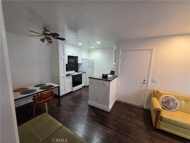 kitchen with electric range, black microwave, freestanding refrigerator, dark wood-style floors, and white cabinets