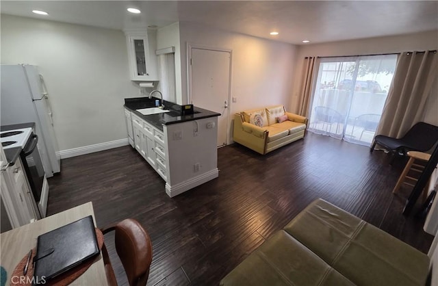 kitchen featuring electric range, a sink, white cabinetry, glass insert cabinets, and dark wood finished floors