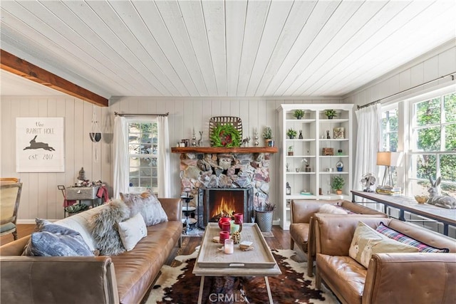 living room featuring a fireplace, wood walls, wood finished floors, and wooden ceiling