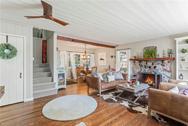 living room with stairs, wood finished floors, a chandelier, a fireplace, and a ceiling fan
