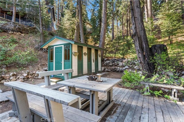 deck featuring an outbuilding and outdoor dining area