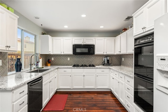 kitchen featuring a sink, black appliances, white cabinets, backsplash, and recessed lighting